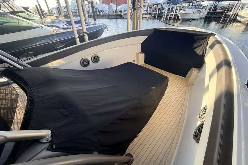 Slide: The Image of 2014 Nor-Tech 340 Sport boat interior with black covers, docked at marina. - 34