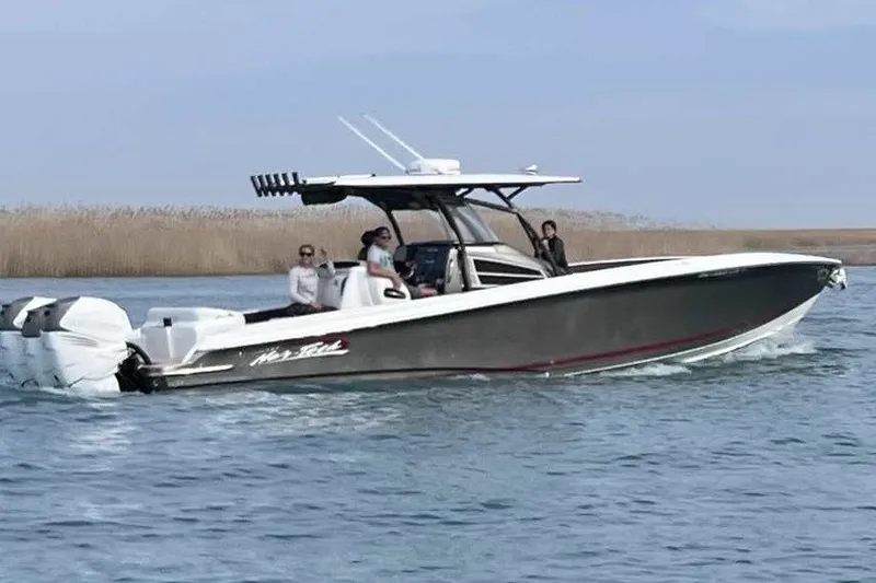 The Image of 2014 Nor-Tech 340 Sport boat cruising on water with passengers onboard. - 0