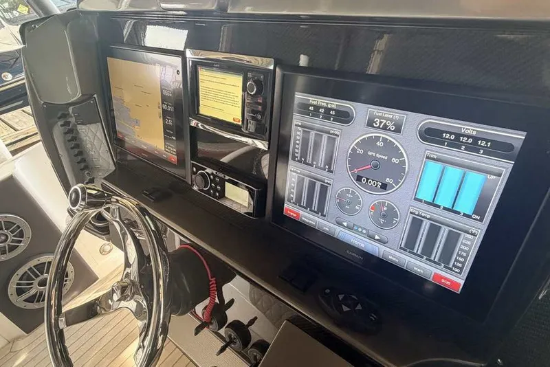 Slide: The Image of Dashboard of a 2014 Nor-Tech 340 Sport boat with navigation and control screens. - 16