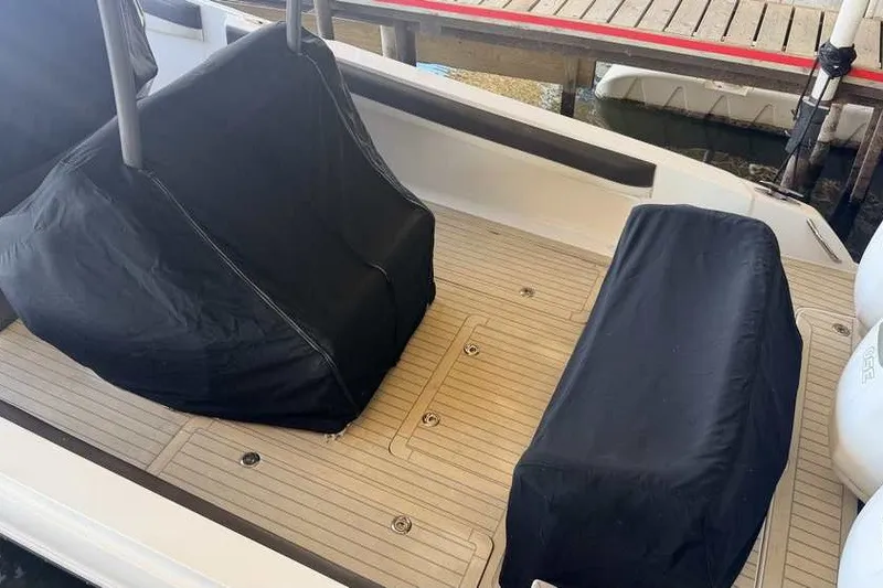 Slide: The Image of 2014 Nor-Tech 340 Sport boat interior with covered seating on a wooden deck. - 35