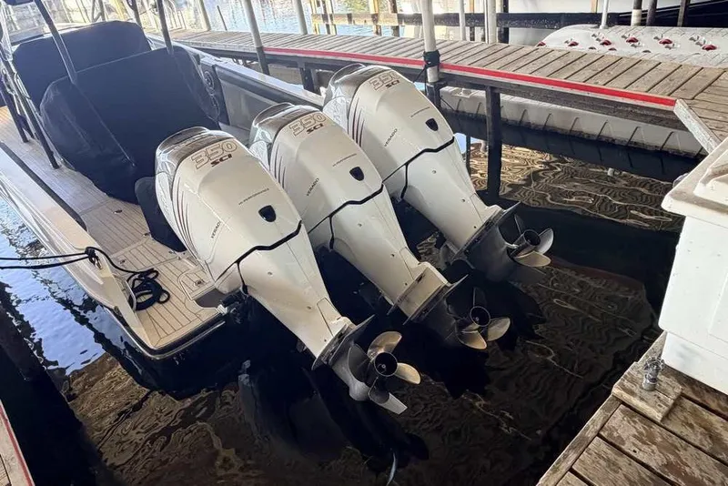 Slide: The Image of 2014 Nor-Tech 340 Sport boat with triple outboard engines docked in marina. - 1