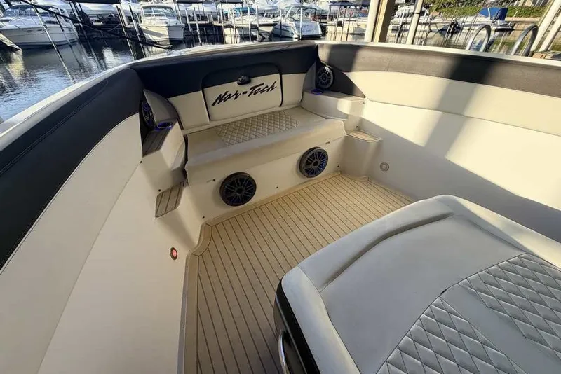 Slide: The Image of 2014 Nor-Tech 340 Sport boat interior with cushioned seating and speakers. - 26