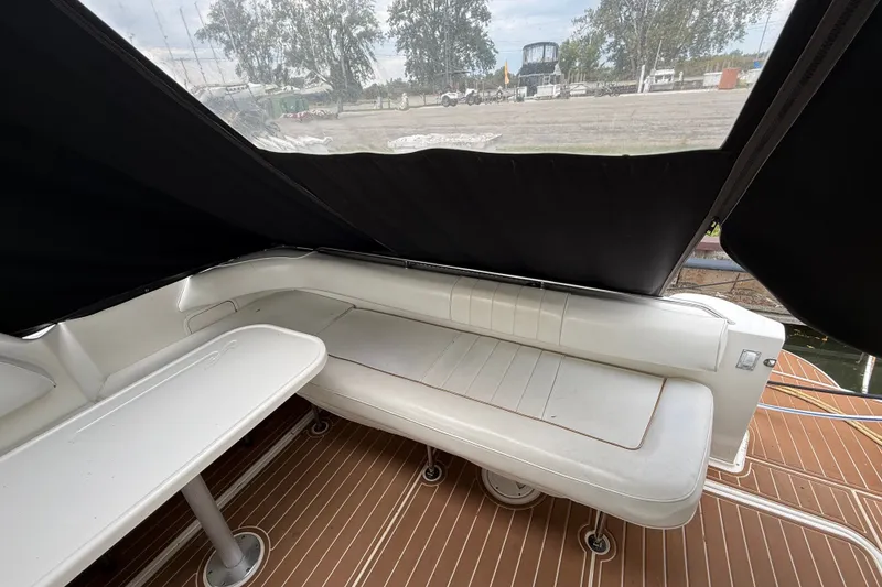 Slide: The Image of 1997 Sea Ray Sundancer 400 interior with white seating and table under black canopy. - 15