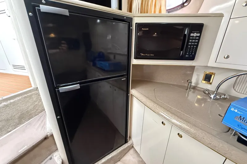 Slide: The Image of 1997 Sea Ray Sundancer 400 kitchen with black fridge, microwave, and sink. - 37