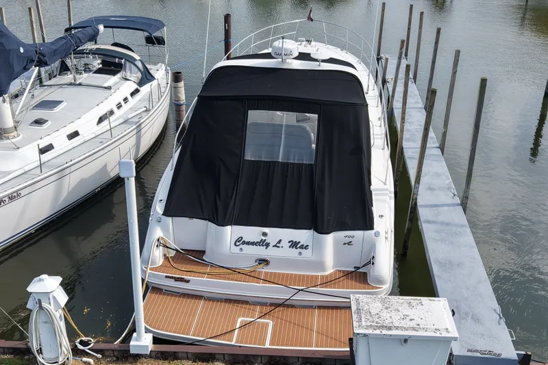 Slide: The Image of 1997 Sea Ray Sundancer 400 yacht docked at marina, rear view with black cover. - 2