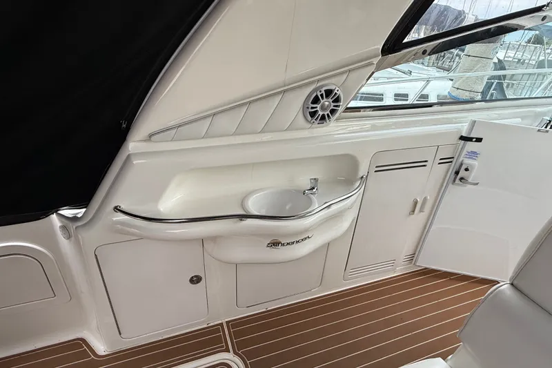 Slide: The Image of 1997 Sea Ray Sundancer 400 interior with sink, storage, and wood-patterned flooring. - 14