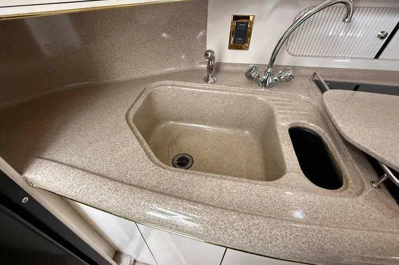 Slide: The Image of Kitchen sink area in a 1997 Sea Ray Sundancer 400 yacht, featuring a sleek countertop design. - 34