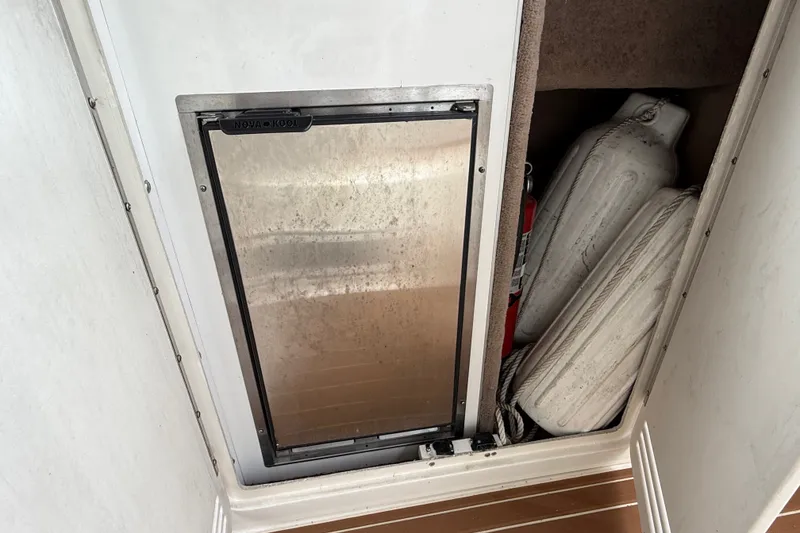 Slide: The Image of Storage compartment on a 1997 Sea Ray Sundancer 400 with fenders and a fire extinguisher. - 24