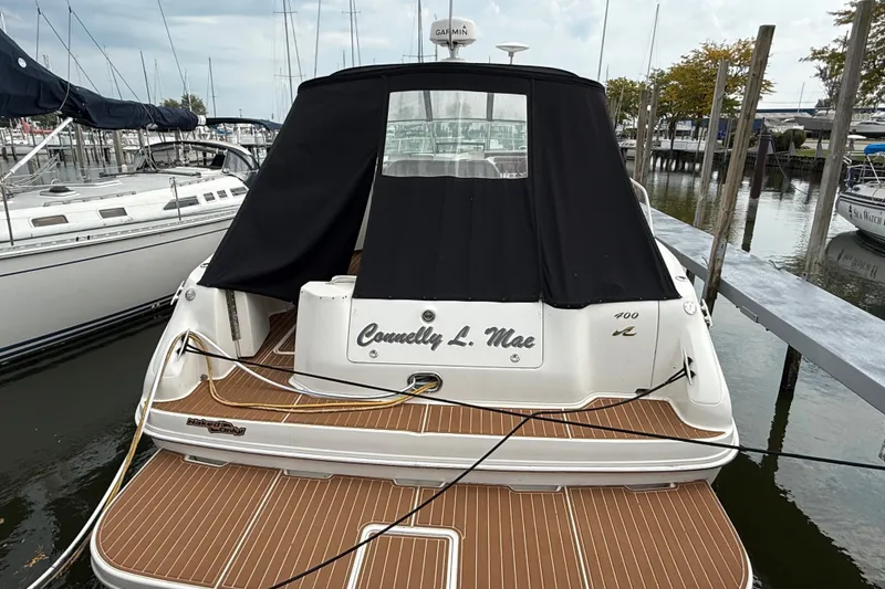 Slide: The Image of 1997 Sea Ray Sundancer 400 docked, featuring teak deck and black canvas cover. - 10