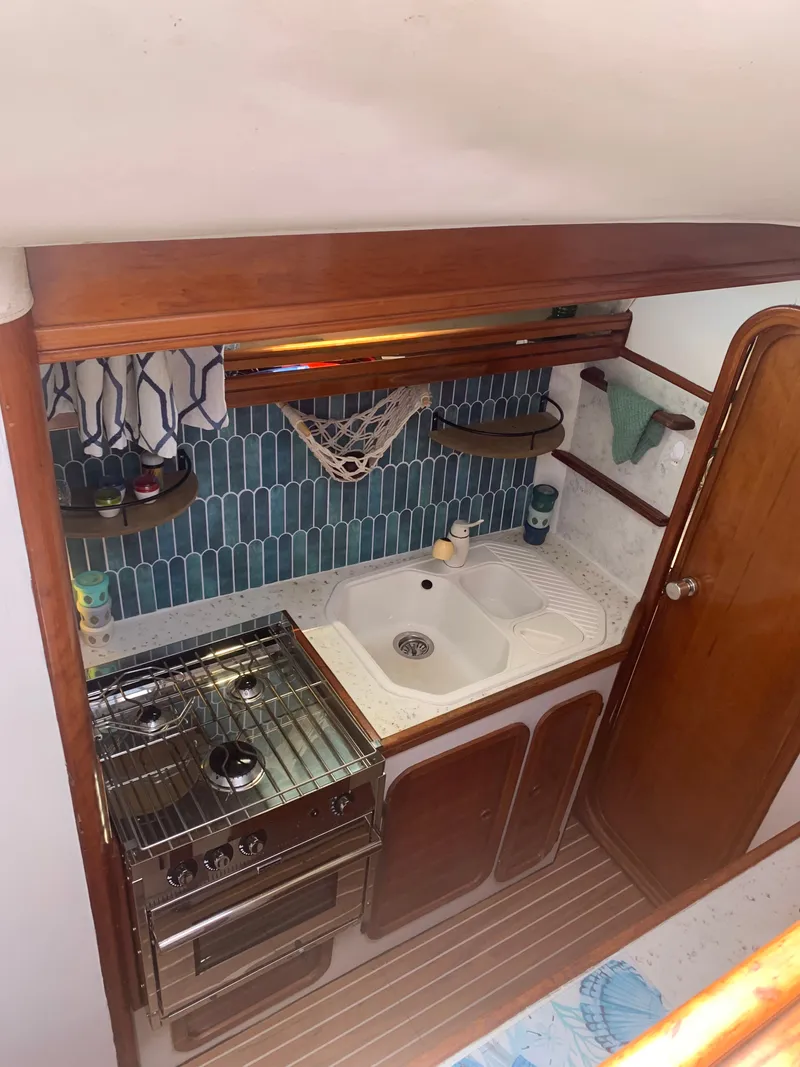 Slide: The Image of Galley in a 1990 Jeantot Privilege 39 with stove, sink, and blue tiles. - 43