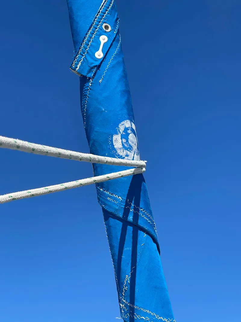 Slide: The Image of Close-up of a blue sail with ropes against a clear sky. - 17