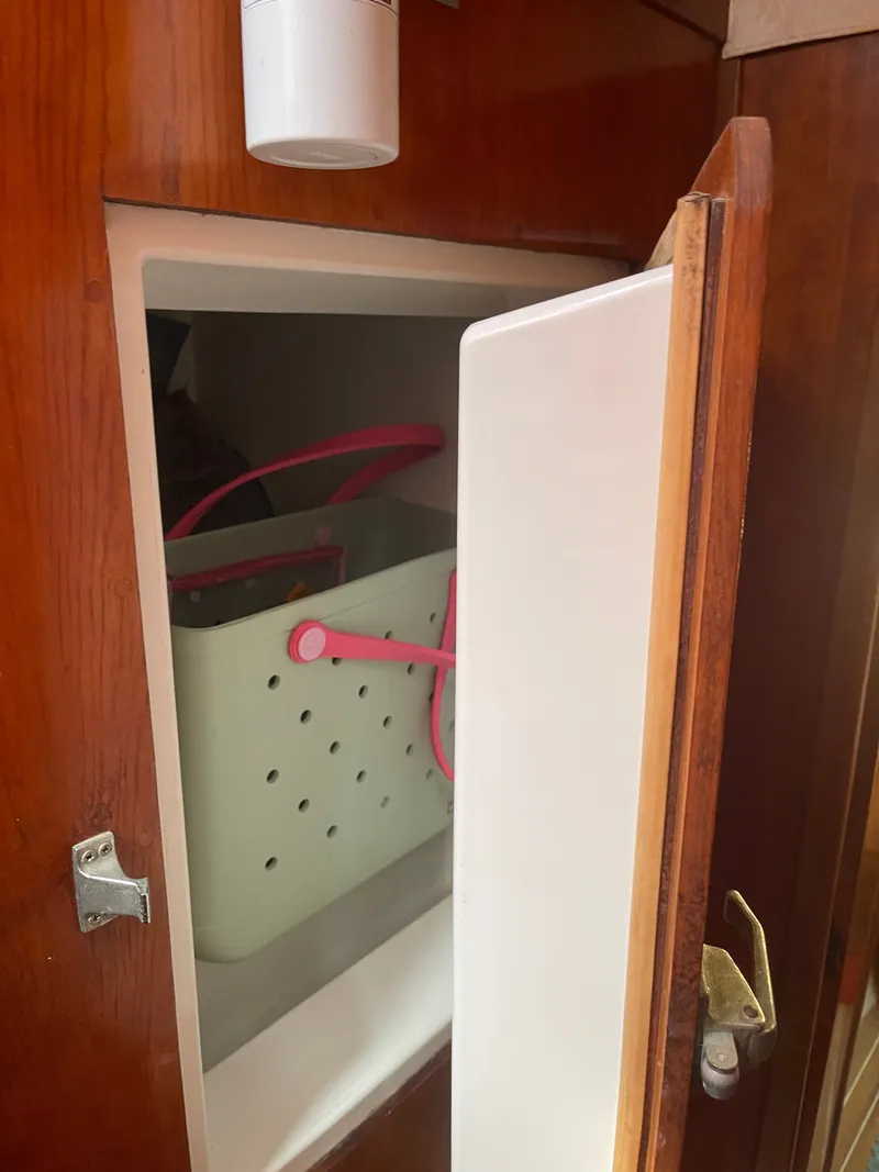 Slide: The Image of An open cabinet with a white container featuring pink handles inside. - 41