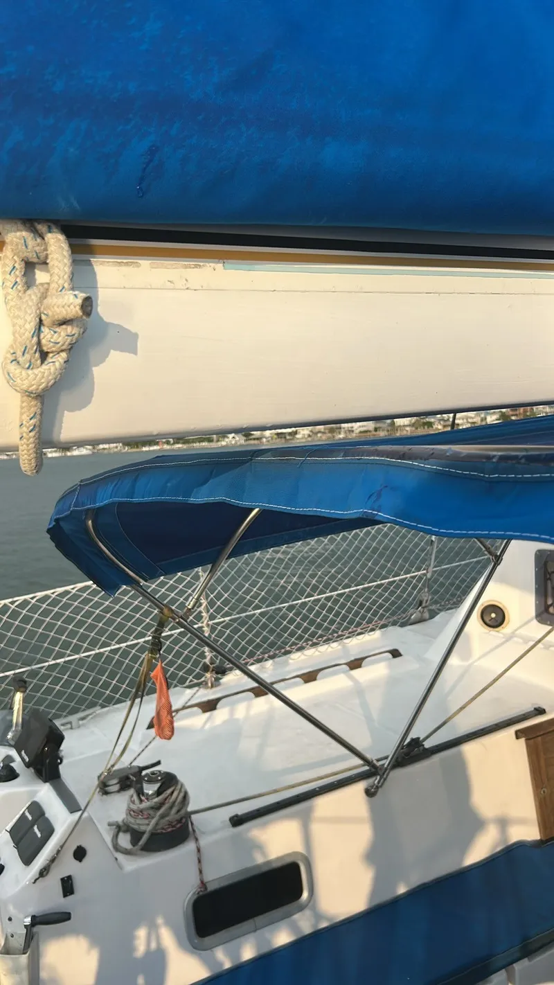 Slide: The Image of A sailboat with blue sunshade and winches on the deck. - 22