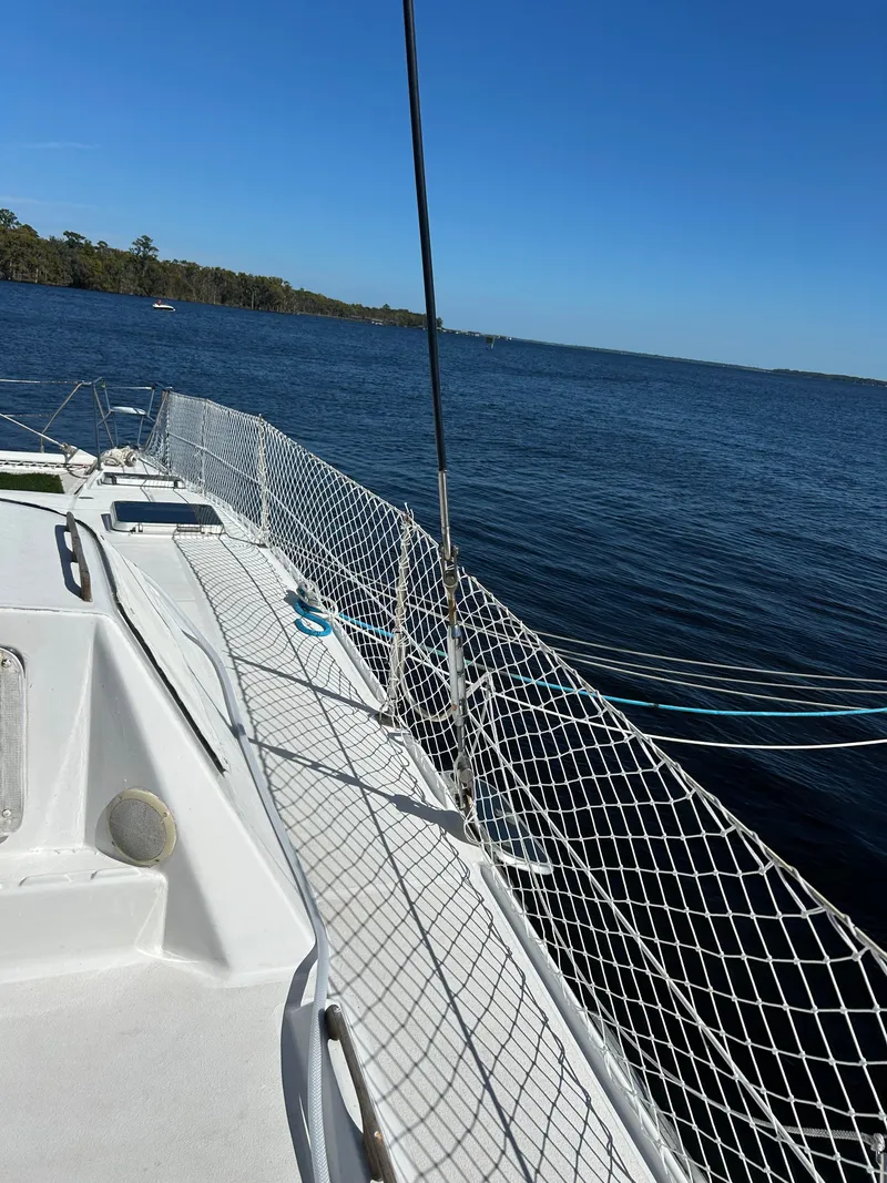 Slide: The Image of The deck of a 1990 Jeantot Privilege 39 with nets along the sides. - 16