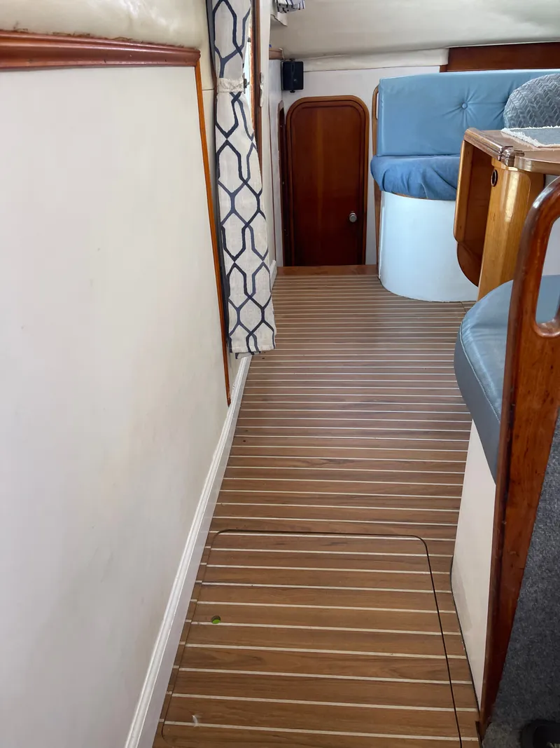 Slide: The Image of Interior of a 1990 Jeantot Privilege 39 with wood flooring and blue upholstery. - 42