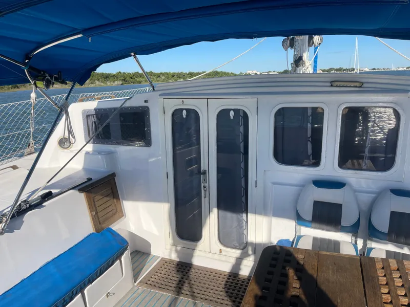 Slide: The Image of The image shows the cockpit of a 1990 Jeantot Privilege 39 with blue cushions and a wooden table. - 32