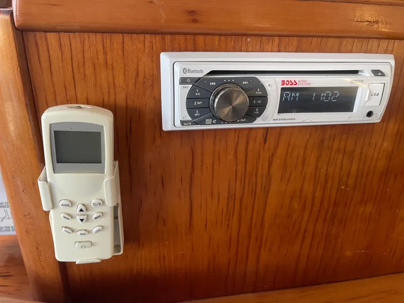 Slide: The Image of A wooden panel with a built-in radio and a remote control holder. - 36