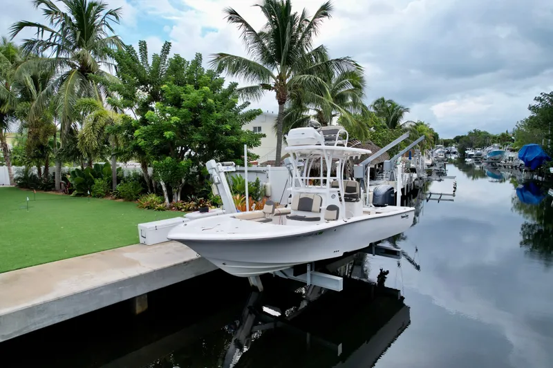 Slide: The Image of 2021 Tidewater 2500 Carolina Bay boat docked by a lush, tropical canal. - 2