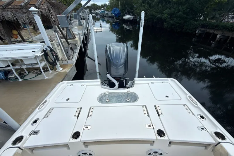 Slide: The Image of 2021 Tidewater 2500 Carolina Bay boat docked by a canal with lush surroundings. - 6