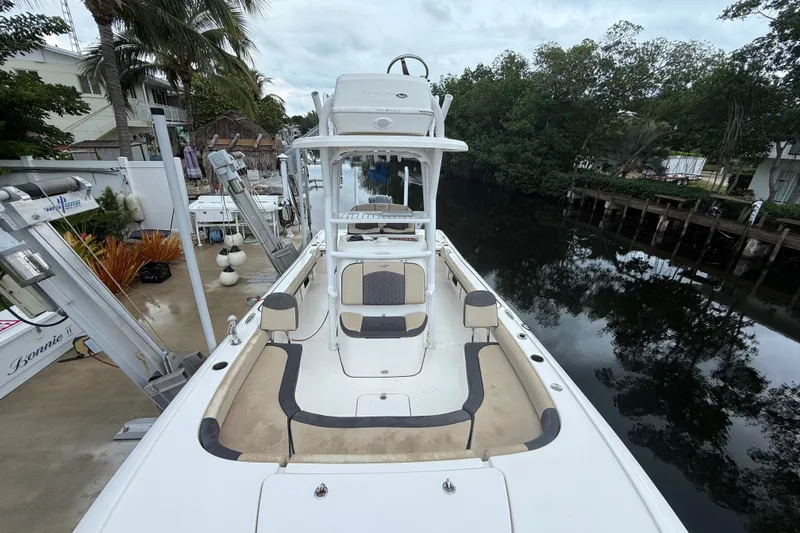 Slide: The Image of 2021 Tidewater 2500 Carolina Bay boat docked near lush greenery and waterfront homes. - 20
