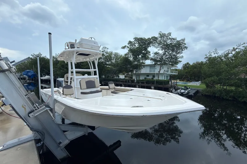 Slide: The Image of 2021 Tidewater 2500 Carolina Bay boat docked near waterfront home, surrounded by trees. - 4