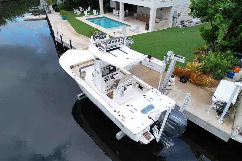 Slide: The Image of 2021 Tidewater 2500 Carolina Bay boat docked by a modern waterfront home with pool. - 3
