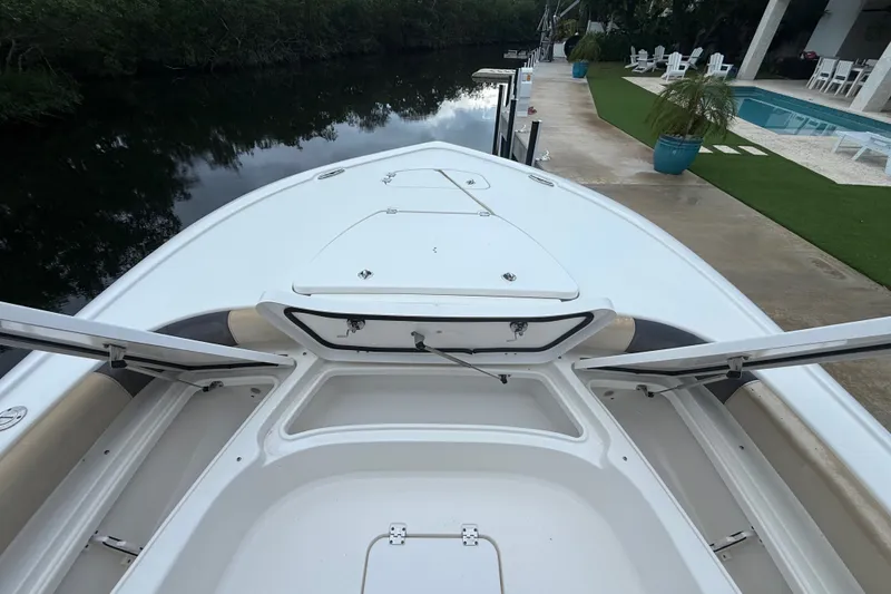 Slide: The Image of 2021 Tidewater 2500 Carolina Bay boat docked by a poolside patio. - 18