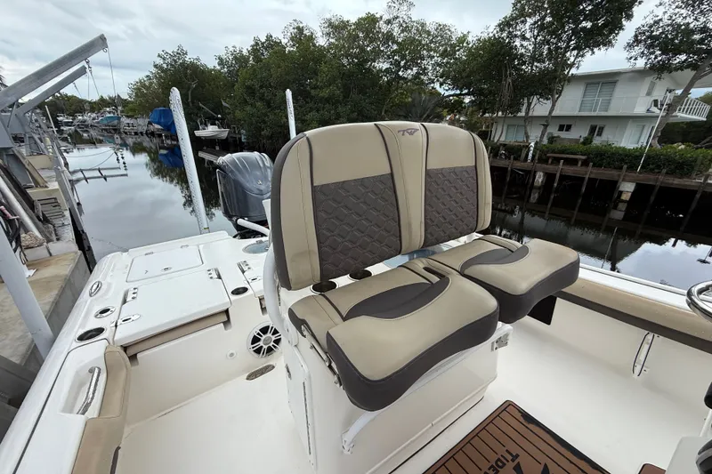 Slide: The Image of 2021 Tidewater 2500 Carolina Bay boat with dual seats, docked near a canal. - 25