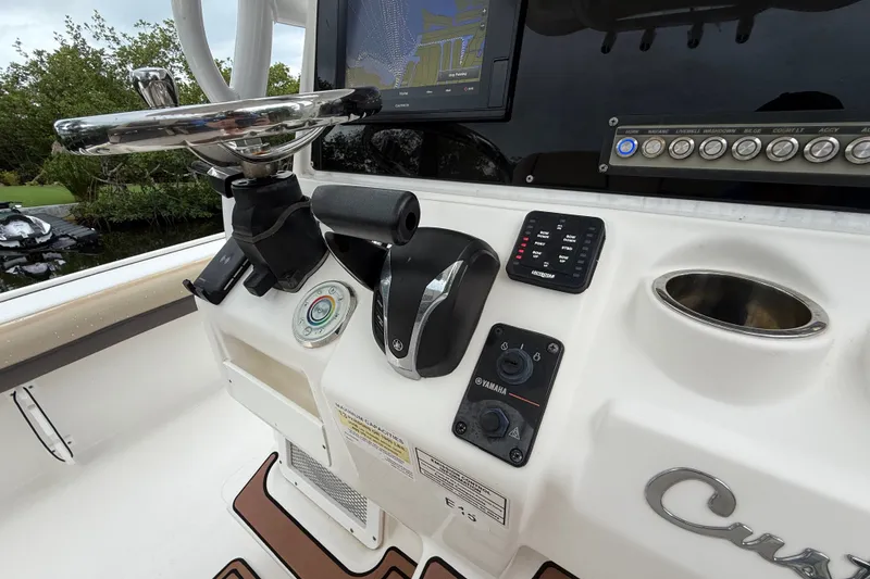 Slide: The Image of 2021 Tidewater 2500 Carolina Bay boat dashboard with steering wheel and control panel. - 13