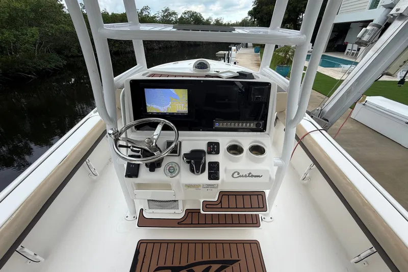 Slide: The Image of 2021 Tidewater 2500 Carolina Bay boat console with navigation screen and steering wheel. - 12