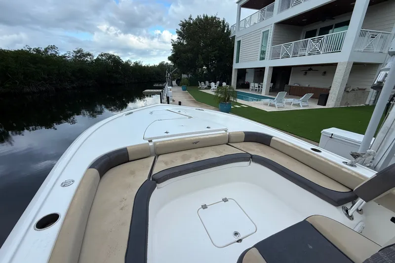 Slide: The Image of 2021 Tidewater 2500 Carolina Bay boat docked near a modern waterfront home with pool. - 15