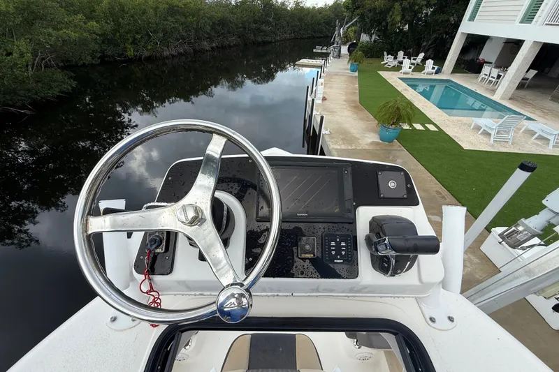 Slide: The Image of Helm of 2021 Tidewater 2500 Carolina Bay boat near a poolside dock. - 26