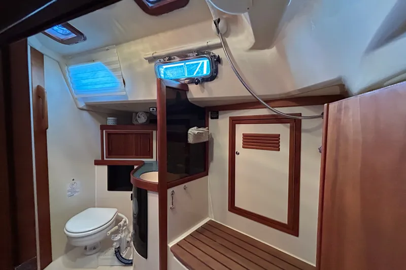 Slide: The Image of Interior of 2001 Sabre 402 yacht bathroom with wooden accents and porthole window. - 21
