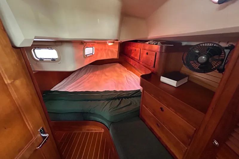 Slide: The Image of Cozy cabin interior of 2001 Sabre 402 sailboat with wooden furnishings and porthole windows. - 25