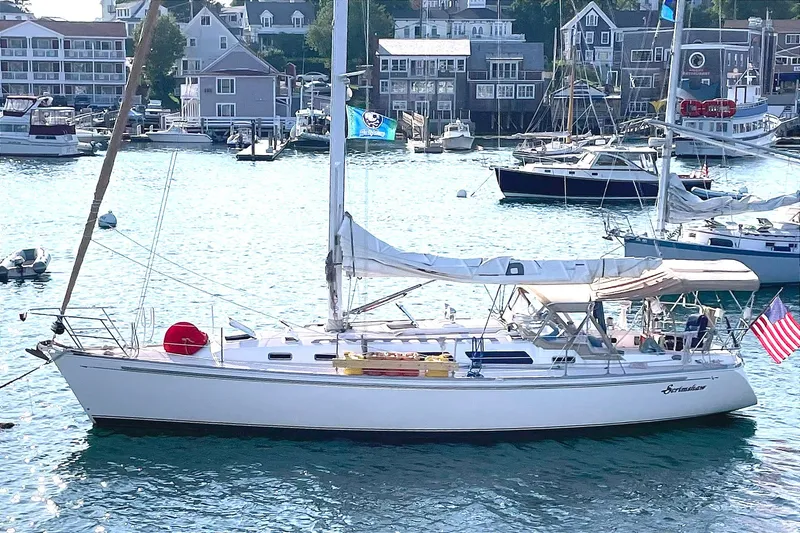 The Image of Sailboat Sabre 402 (2001) docked in a scenic harbor with surrounding boats and buildings. - 0