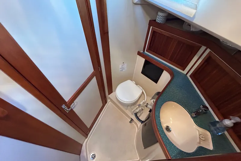 Slide: The Image of Compact bathroom in a 2001 Sabre 402 yacht with wooden accents and modern fixtures. - 22