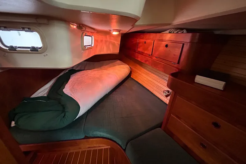 Slide: The Image of Cozy cabin interior of 2001 Sabre 402 sailboat with wooden furnishings and bedding. - 26