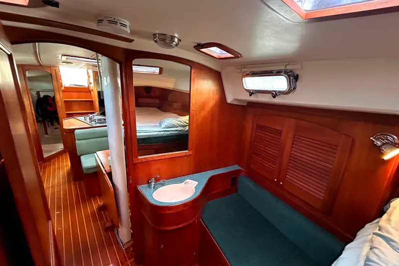 Slide: The Image of Interior of 2001 Sabre 402 sailboat with wood finish, cozy seating, and compact sink. - 18