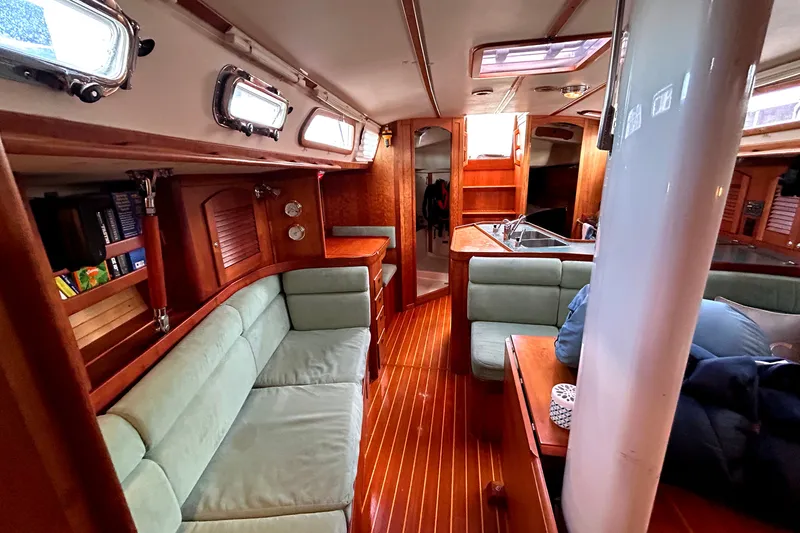 Slide: The Image of Interior of 2001 Sabre 402 sailboat with wooden finishes and cozy seating area. - 9