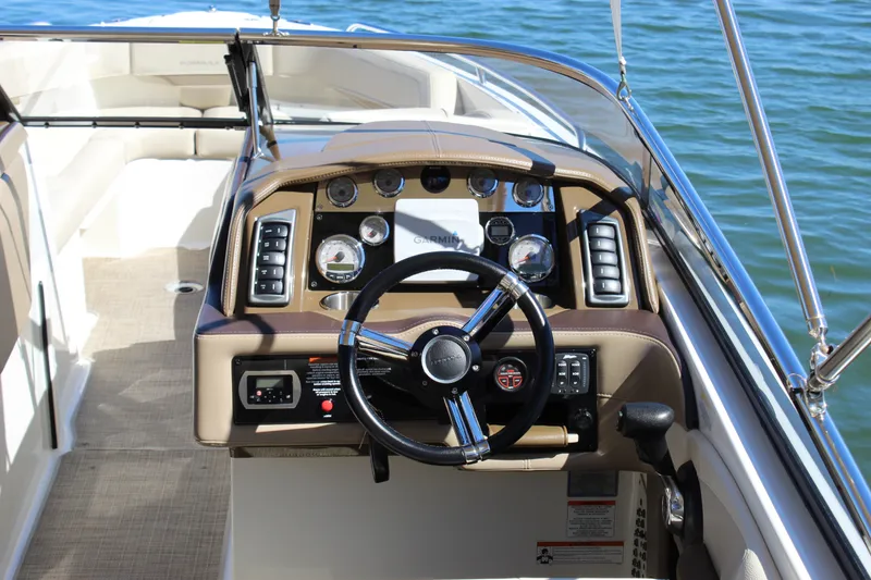 Slide: The Image of 2015 Formula 270 Bowrider dashboard with steering wheel and gauges, on calm water. - 27