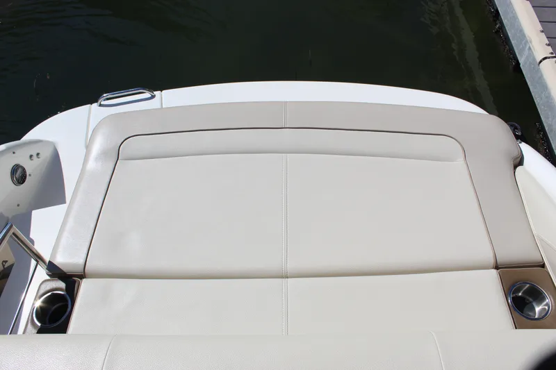 Slide: The Image of 2015 Formula 270 Bowrider boat's rear seating area with cup holders, docked by water. - 36
