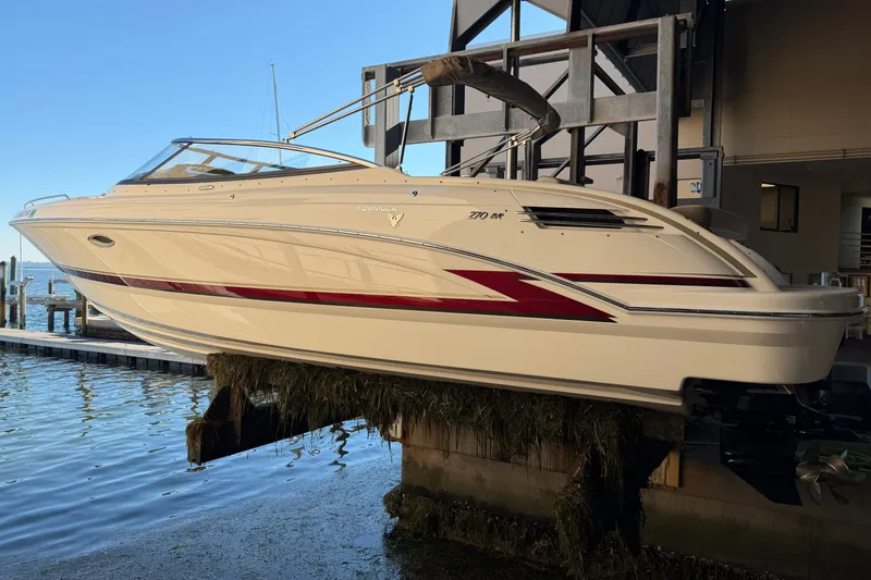 Slide: The Image of 2015 Formula 270 Bowrider boat docked, featuring sleek design and red accents. - 13