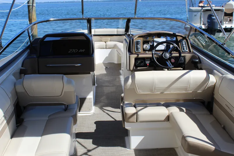 Slide: The Image of 2015 Formula 270 Bowrider interior with beige seating and modern dashboard on the water. - 22