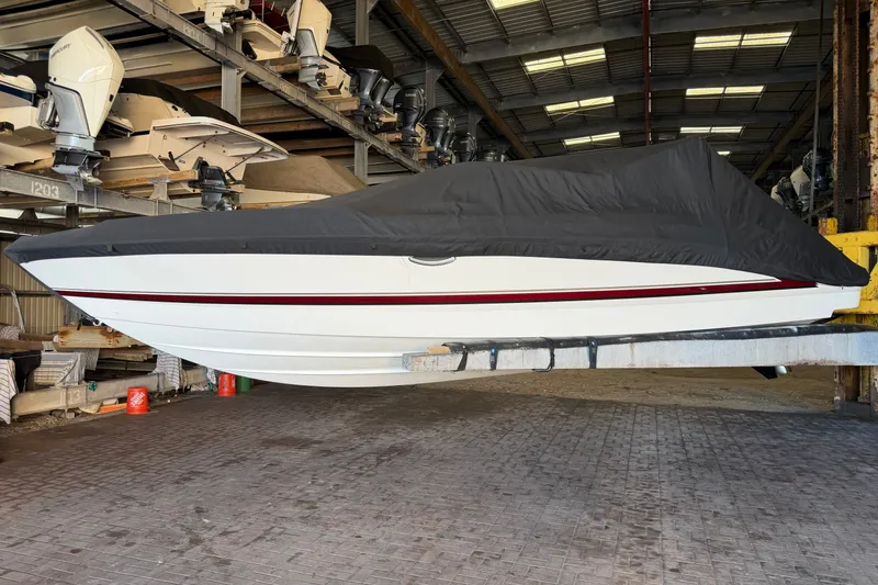 Slide: The Image of 2015 Formula 270 Bowrider boat covered in storage, side view in a warehouse. - 15