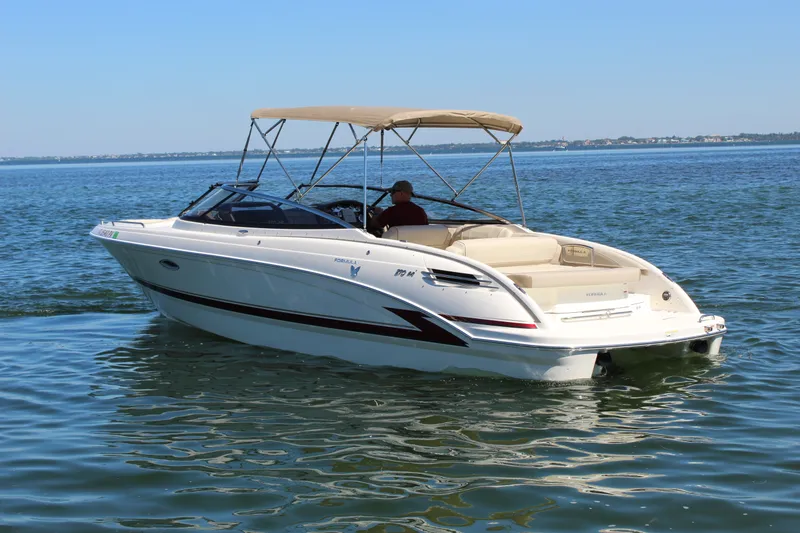 Slide: The Image of 2015 Formula 270 Bowrider boat cruising on calm water with canopy. - 3