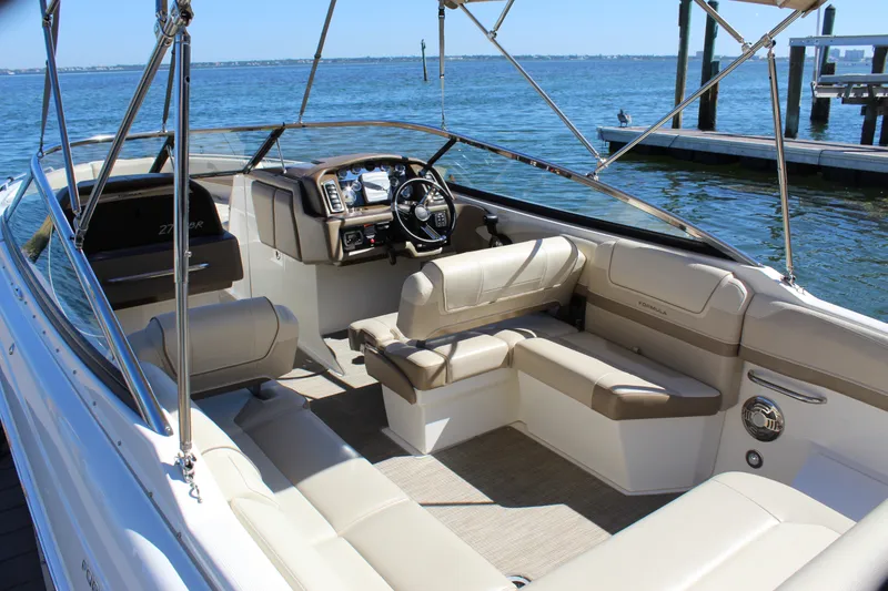 Slide: The Image of 2015 Formula 270 Bowrider boat interior with beige seating, steering wheel, and open water view. - 21