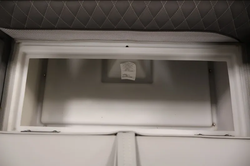 Slide: The Image of Interior storage compartment of 2025 Ranger Reata 220C boat, featuring quilted upholstery. - 18
