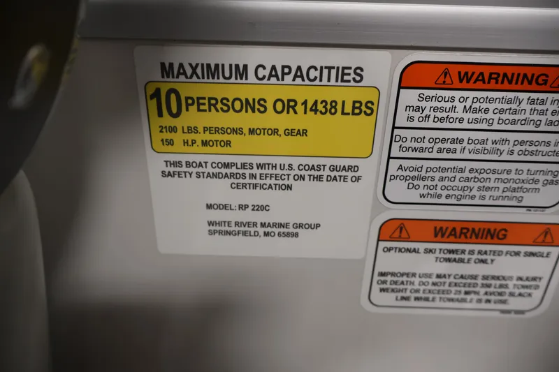 Slide: The Image of 2025 Ranger Reata 220C boat capacity label, 10 persons or 1438 lbs, safety warnings included. - 28