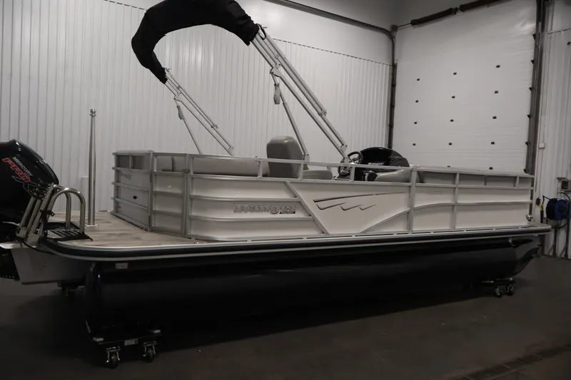 Slide: The Image of 2025 Ranger Reata 220C pontoon boat in a garage, featuring sleek design and modern amenities. - 4