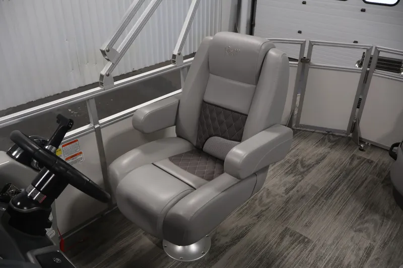 Slide: The Image of 2025 Ranger Reata 220C boat interior with luxurious captain's chair and steering wheel. - 29